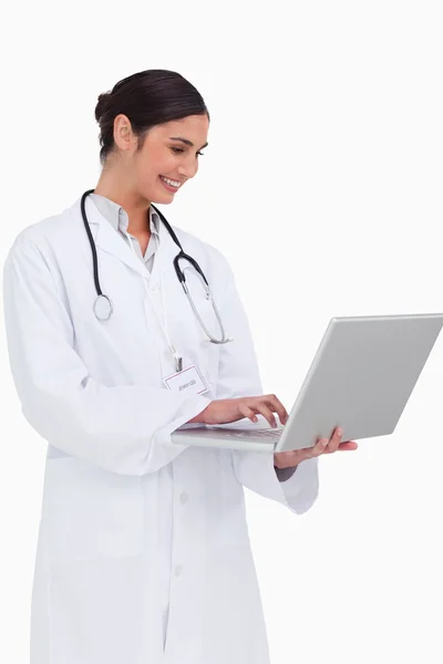 Boční pohled na usmívající se doktor s její laptop — Stock fotografie