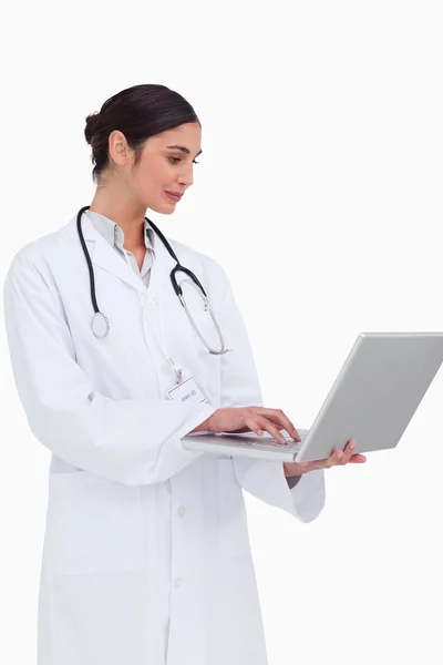 Вид збоку жінки-лікар, що працює на своєму ноутбуці — стокове фото