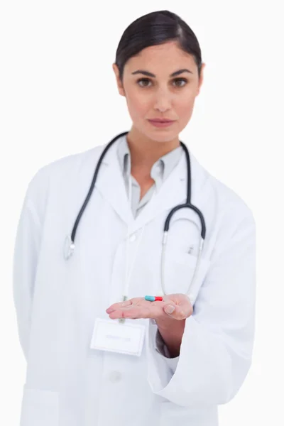 Female doctor holding pill in her palm — Stock Photo, Image