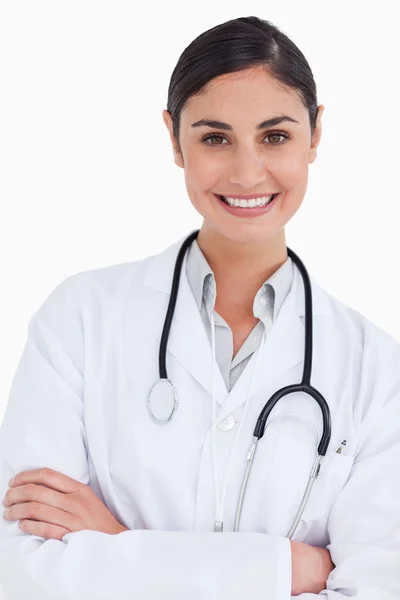 Primo piano di sorridente medico femminile con le braccia incrociate — Foto Stock