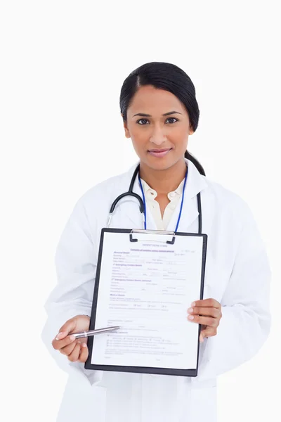 Крупный план женщины-врача, указывающей на форму — стоковое фото