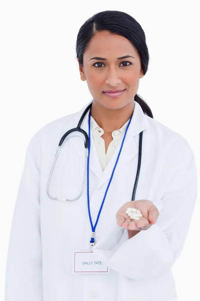 Close up de médico feminino segurando pílulas na palma da mão — Fotografia de Stock