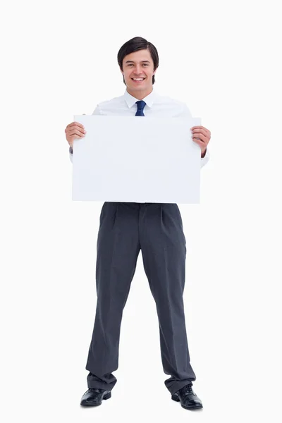 Un comerciante sonriente sosteniendo un cartel en blanco — Foto de Stock