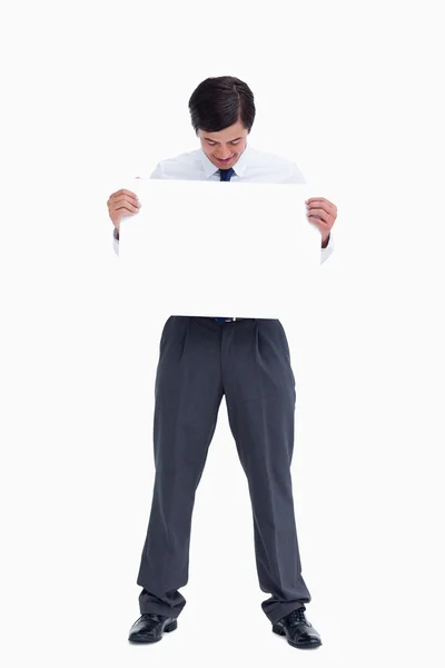 Tradesman looking at blank sign in his hands — Stock Photo, Image