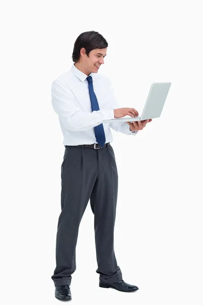 Vista lateral del comerciante sonriente trabajando en su computadora portátil —  Fotos de Stock
