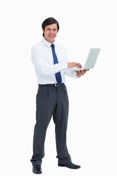 Sidovy av leende handelsmannen med sin laptop — Stockfoto