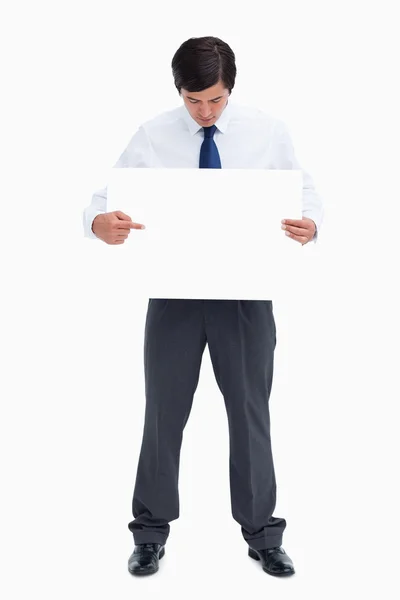 Tradesman pointing at blank sign in his hand — Stock Photo, Image