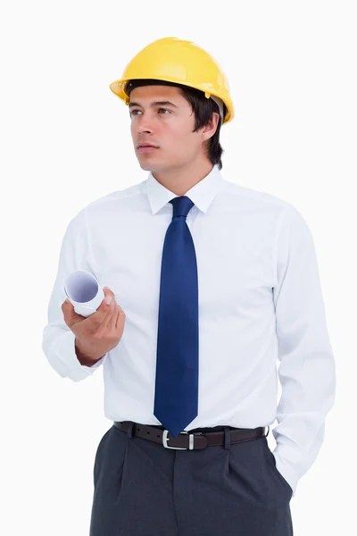 Arquiteto masculino com capacete e planos olhando para o lado — Fotografia de Stock