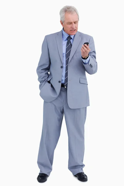 Mature tradesman looking angry at his cellphone — Stock Photo, Image