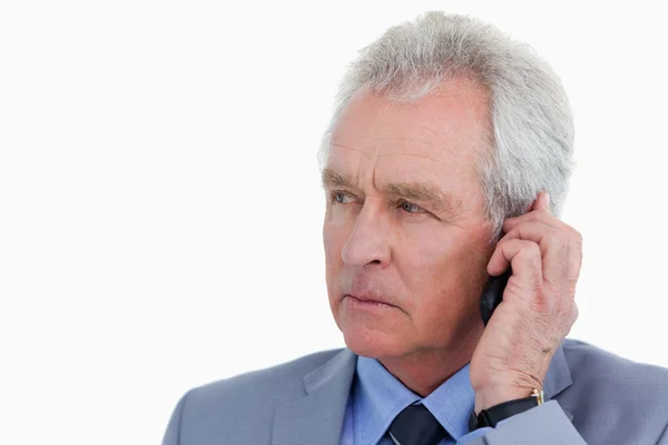 Close up of mature tradesman listening to caller — Stock Photo, Image