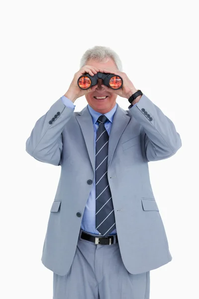 Smiling mature tradesman looking through spy glass — Stock Photo, Image