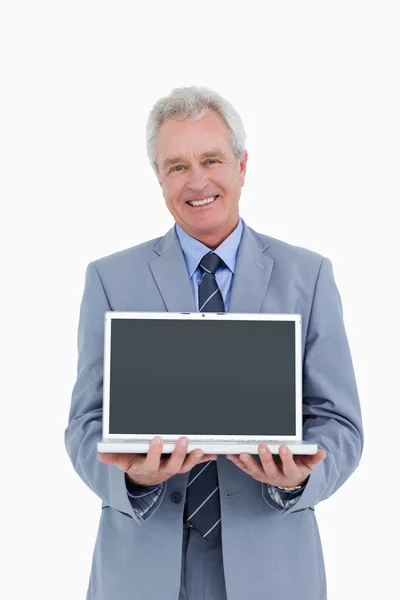 Glimlachend volwassen handelaar presenteren scherm van zijn laptop — Stockfoto