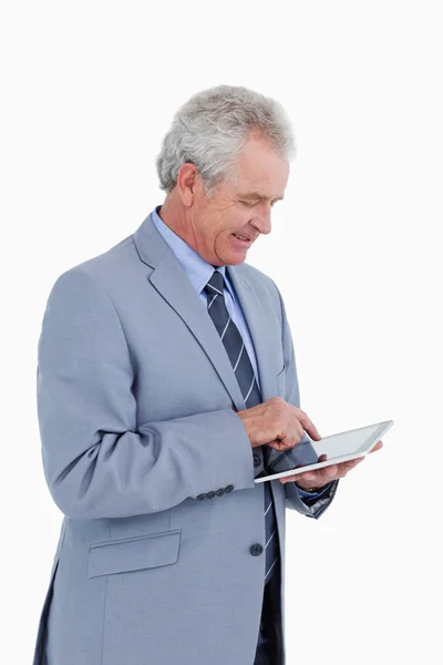 Zijaanzicht van lachende volwassen handelaar met behulp van tablet pc — Stockfoto