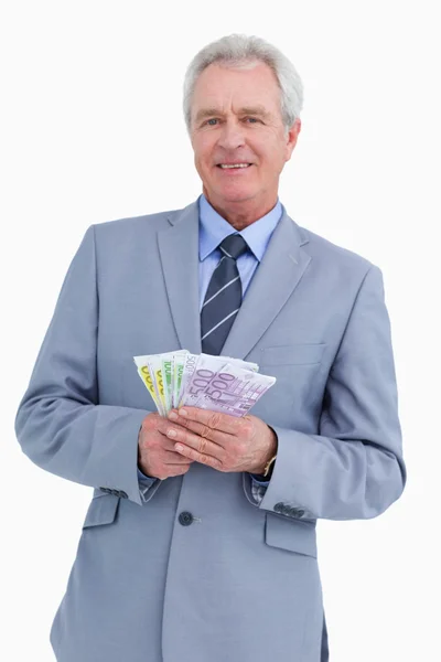 Sorrindo comerciante maduro com notas bancárias em suas mãos — Fotografia de Stock