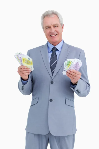 Lachende volwassen handelaar met contant geld in zijn handen — Stockfoto