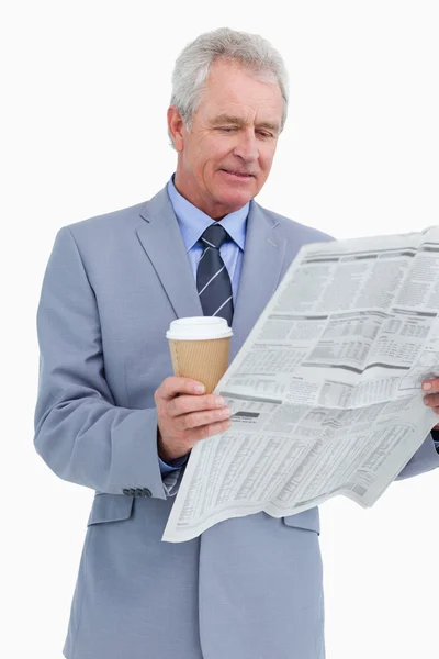 Comerciante maduro com papel de notícia e copo de papel — Fotografia de Stock