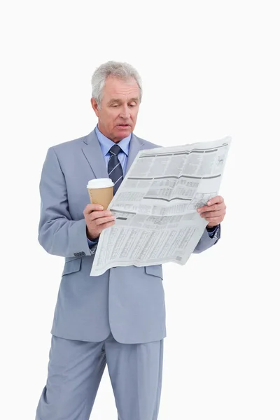 Mature tradesman with paper cup reading news paper — Stock Photo, Image