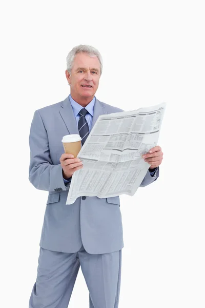 Mature tradesman holding news paper and paper cup — Stock Photo, Image