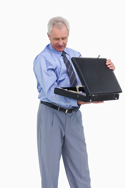 Starší obchodník při pohledu do jeho kufr — Stock fotografie