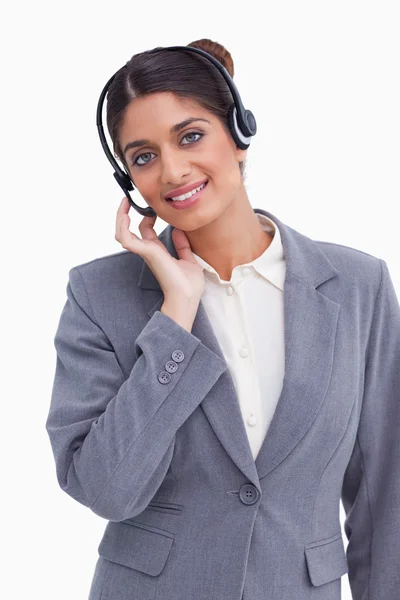 Sonriente agente del centro de llamadas femenino ajustando sus auriculares —  Fotos de Stock