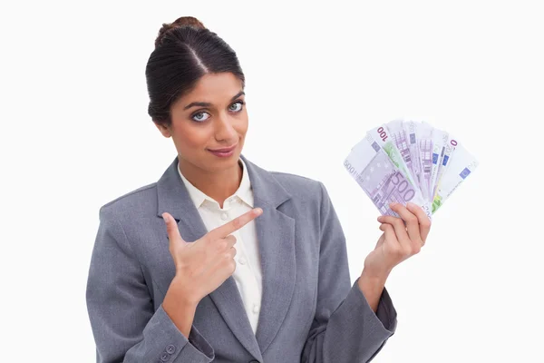 Female entrepreneur pointing at money in her hand — Stock Photo, Image