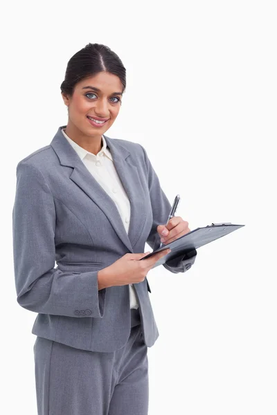 Smiling female entrepreneur with clipboard and pen — Stock Photo, Image