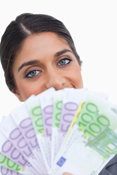 Gros plan d'une femme entrepreneure cachant son visage derrière un billet de banque — Photo