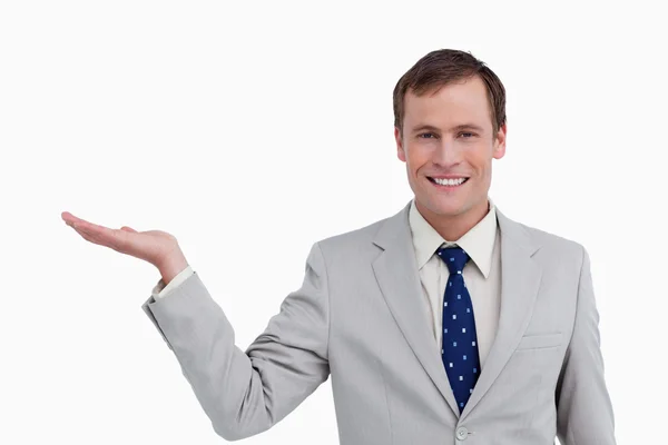 Primer plano de un hombre de negocios sonriente con la palma hacia arriba — Foto de Stock