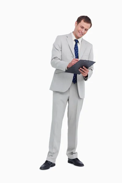 Un hombre de negocios sonriente tomando notas — Foto de Stock