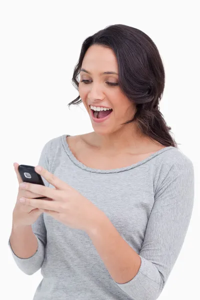 Закройте счастливую женщину, читающую СМС — стоковое фото