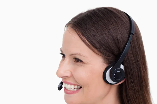 Close up vista lateral de sorrindo agente de call center feminino — Fotografia de Stock