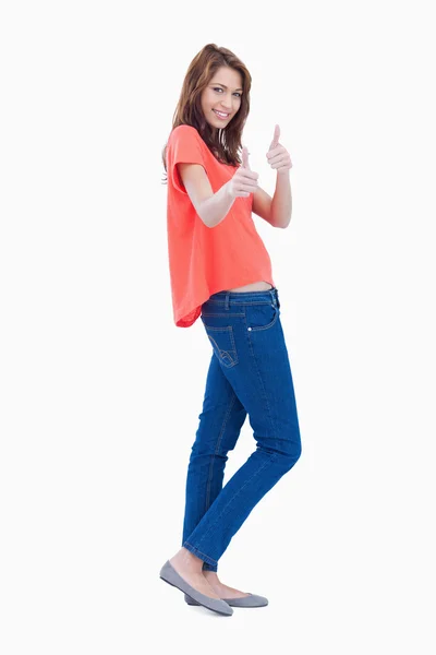 Vista lateral de una adolescente mostrando sus dos pulgares hacia arriba —  Fotos de Stock