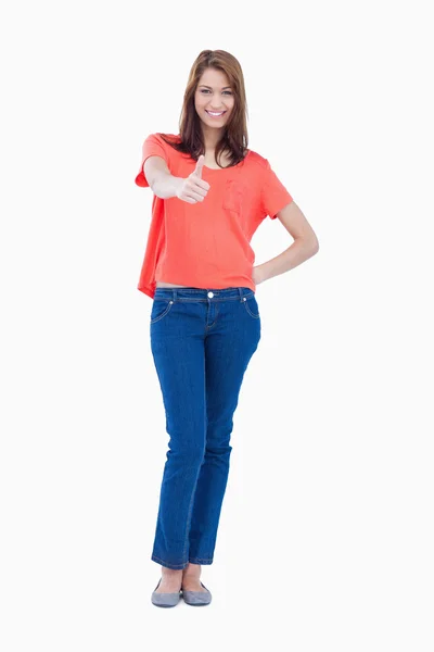 Adolescente em pé contra um fundo branco com um polegar para cima — Fotografia de Stock