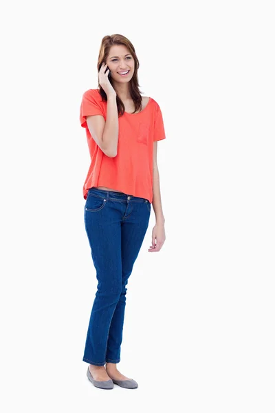 Adolescente de pie contra un fondo blanco mientras hace una llamada — Foto de Stock