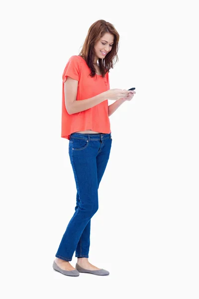 Ragazza adolescente in piedi in piedi durante l'invio di un testo — Foto Stock