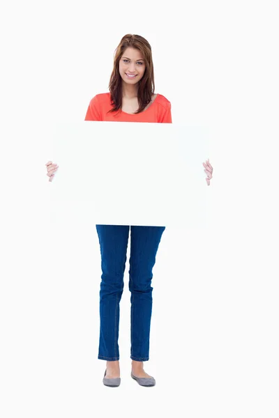 Tonåring håller en tom affisch mot vit bakgrund — Stockfoto