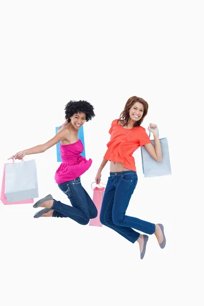 Young teenagers energetically jumping after going shopping — Stock Photo, Image