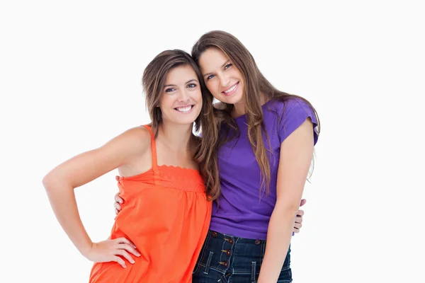 Sonrientes mujeres jóvenes tomando unos a otros por la cintura —  Fotos de Stock