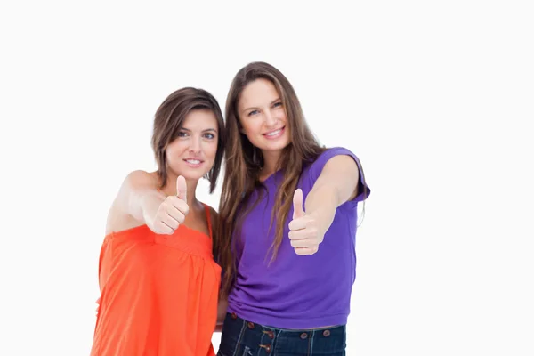 Two teenagers putting their thumbs up while smiling — Stock Photo, Image