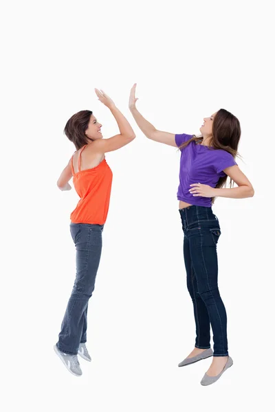 Teenagers jumping while giving each other a high-five — Stock Photo, Image