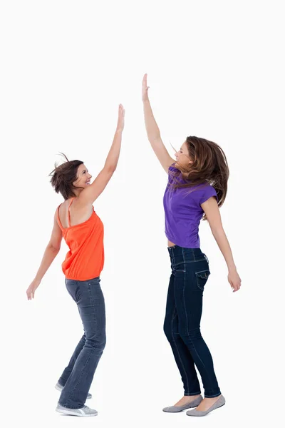 A teenage girl keeping her hand in the air while her best friend — Stock Photo, Image