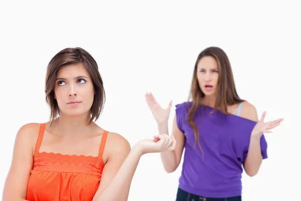 Adolescente exasperada de pie erguida mientras su amiga está rugiendo —  Fotos de Stock