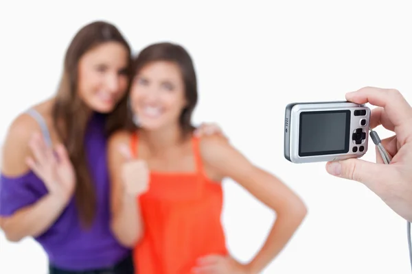 Two teenage girls photographed by a friend holding a digital cam — Stock Photo, Image