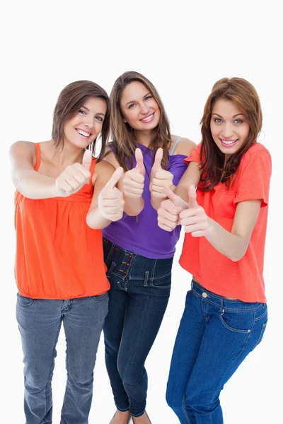 Teenage girls showing their happiness by putting their thumbs up — Stock Photo, Image