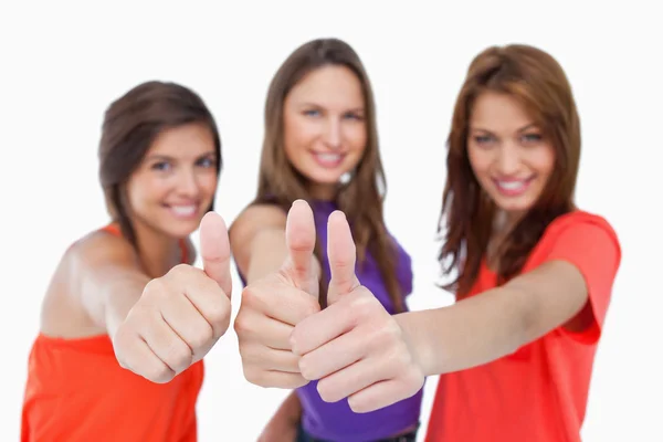 Smiling teenagers showing their approval by putting their thumbs — Stock Photo, Image