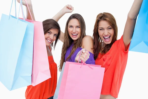 Mujeres jóvenes elevando sus bolsas de compra — Foto de Stock
