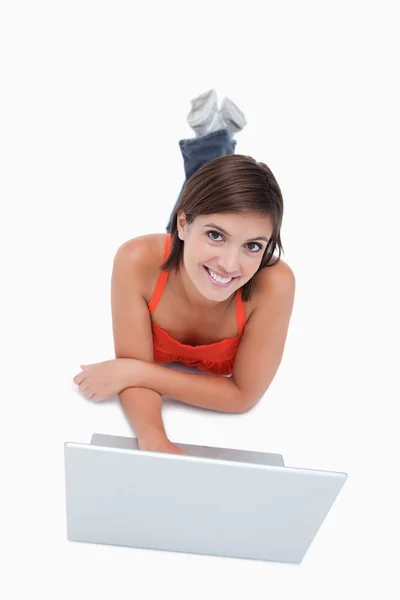 Glimlachend tiener overschrijding haar armen en benen terwijl liggen — Stockfoto