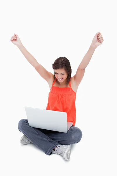 Adolescente mostrando su satisfacción detrás de su computadora portátil mientras pasa pasas —  Fotos de Stock