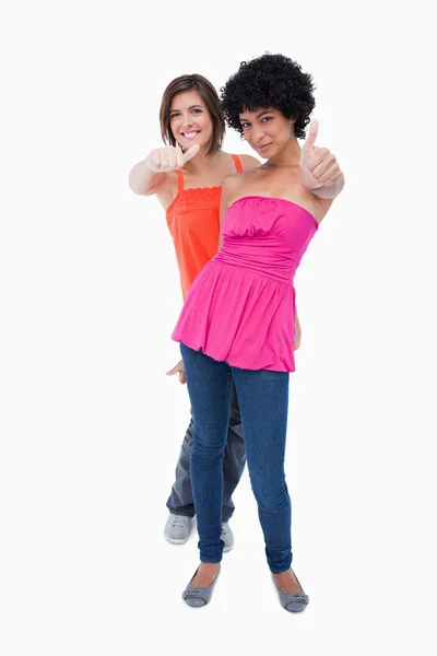 Feliz adolescente mostrando pulgares hacia arriba uno detrás del otro adolescente —  Fotos de Stock