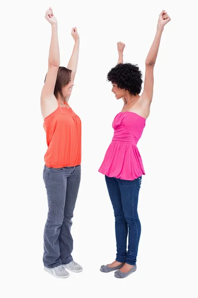 Two dynamic teenagers raising their arms in satisfaction — Stock Photo, Image